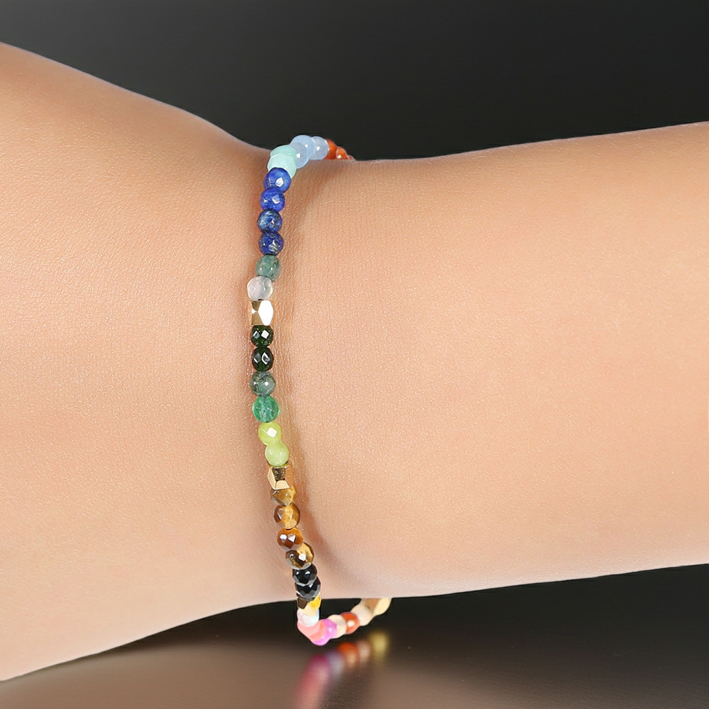 Seven chakras colored stones bracelet on wrist, multicolor beads with black clasp beads
