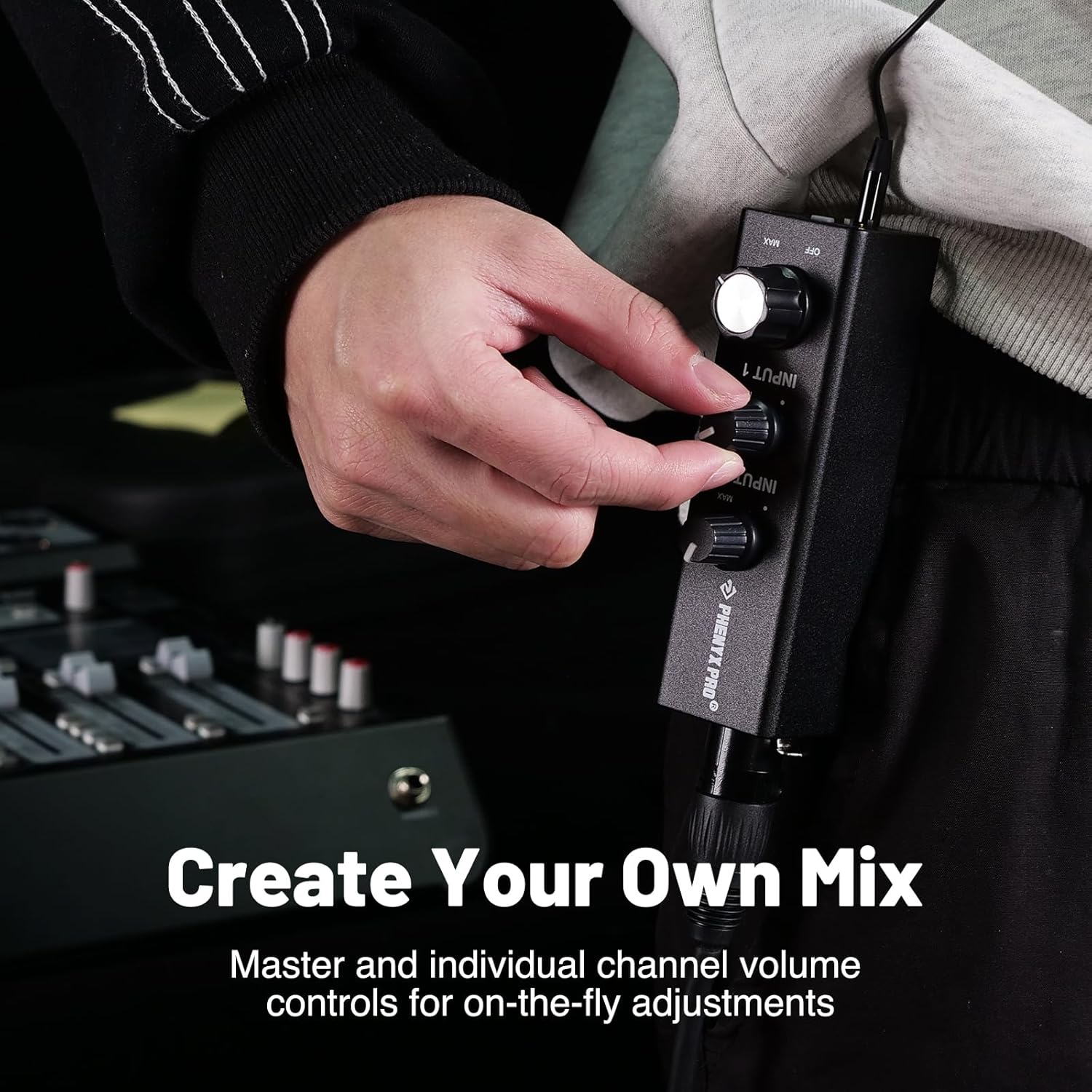 Phenyx Pro in-ear monitor amplifier with volume knobs being adjusted by hand